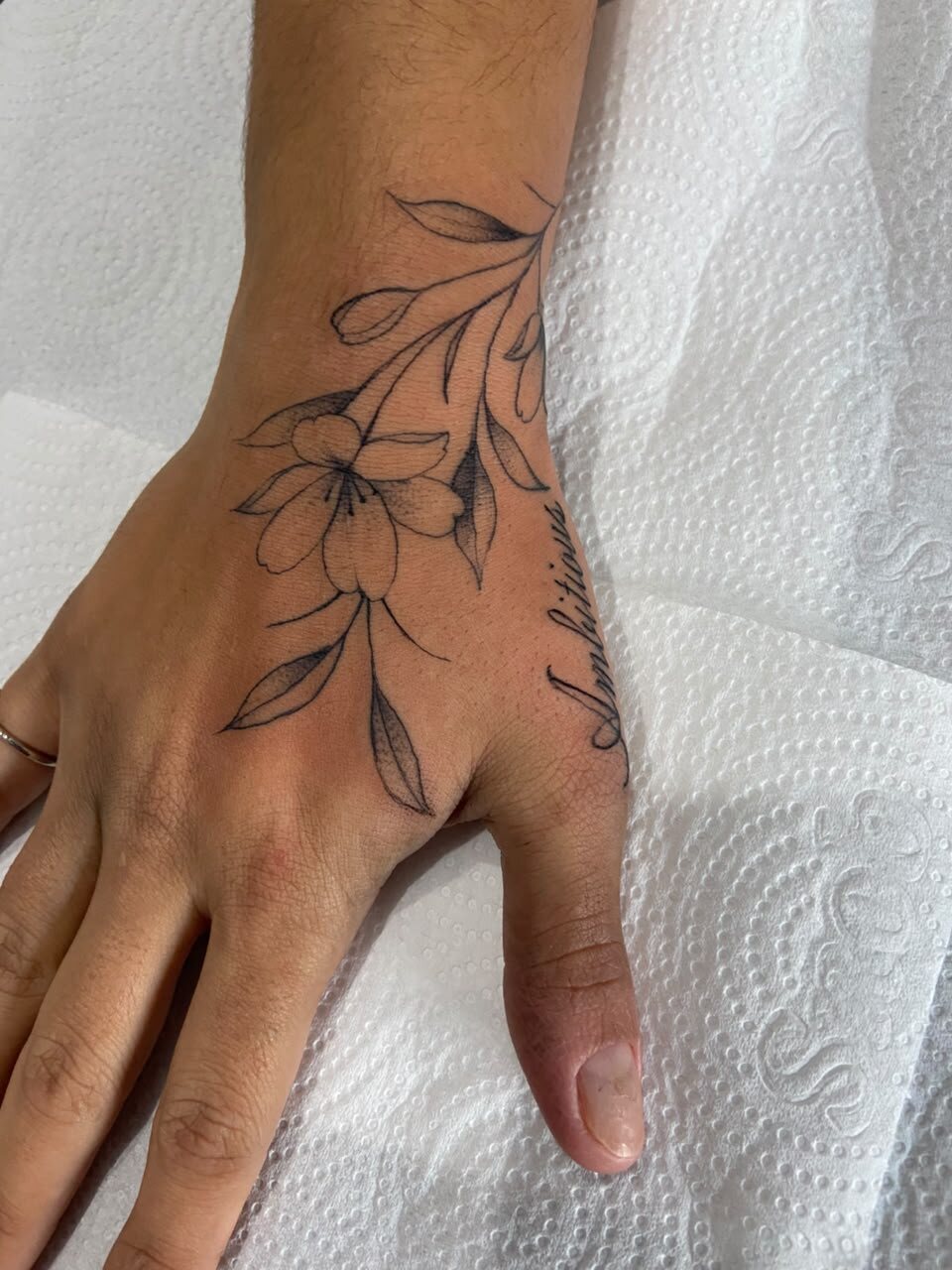 Flores delicadas em fine line na mão